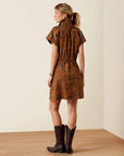 Rear three-quarter view of the Ariat Cody Dress, a brown western mini dress with subtle print, paired with dark brown cowboy boots
