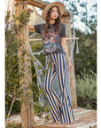 Model in striped flare jeans standing on grass with hammock hanging in background