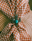 Brown and White Houndstooth Wild Rag fastened with a cactus scarf slide