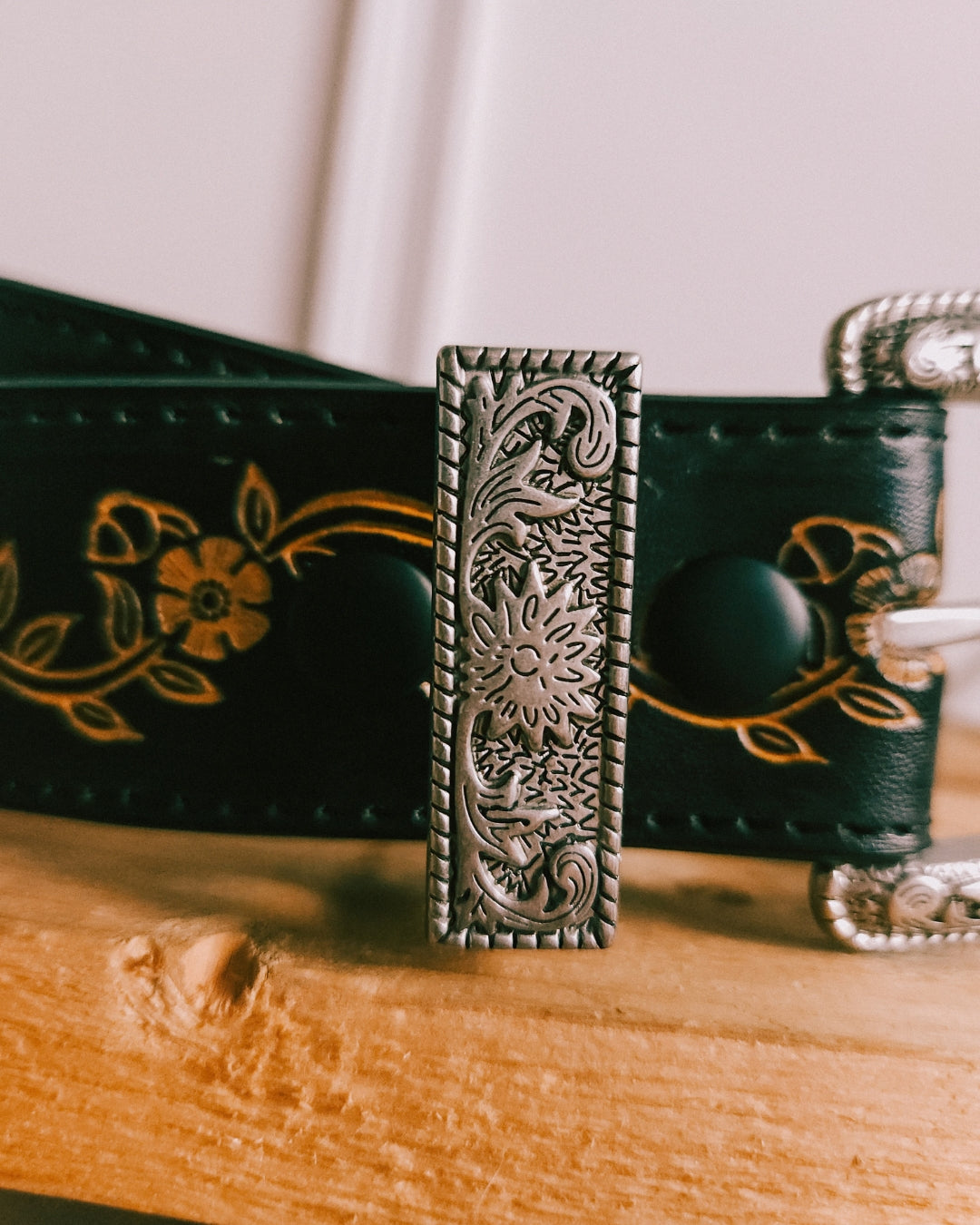 Full length view of the black floral tooled leather belt by Axesoria West
