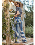 Back view of model wearing high-waisted Austin striped denim flares with hammock behind her