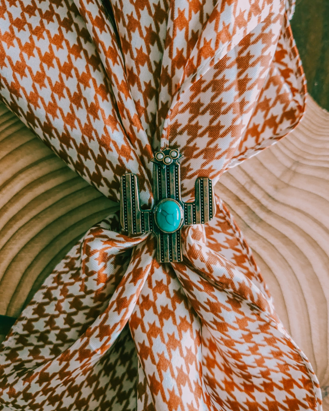 Brown and White Houndstooth Wild Rag fastened with a cactus scarf slide