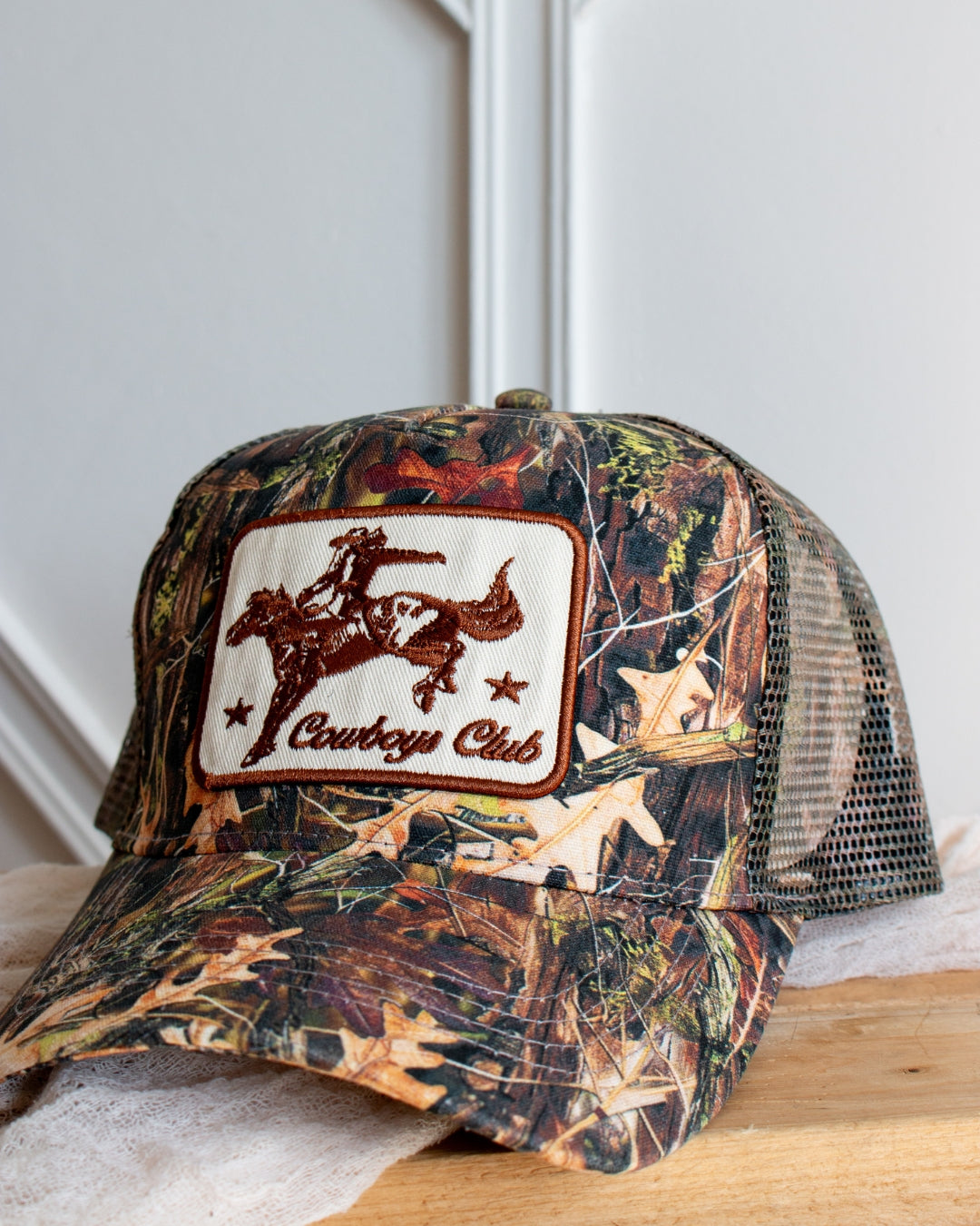 Western camo cowboy trucker cap with embroidered cowboy patch, front view