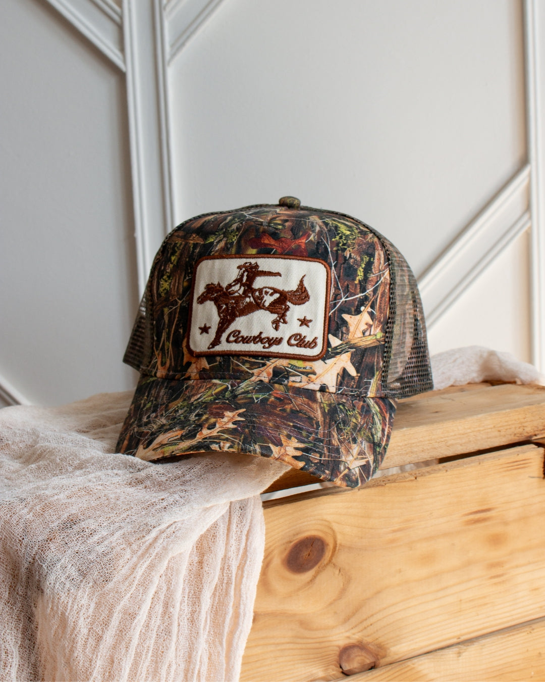 Camouflage cowboy trucker cap with snapback adjuster and mesh panel