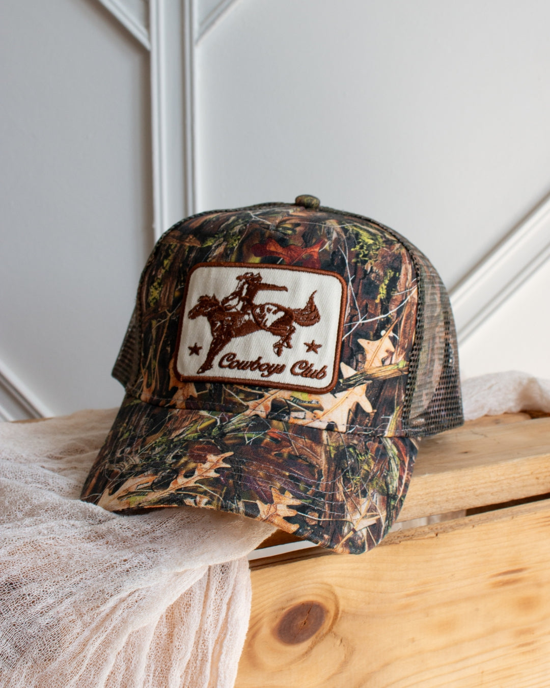Camouflage western trucker cap with embroidered cowboy patch detail