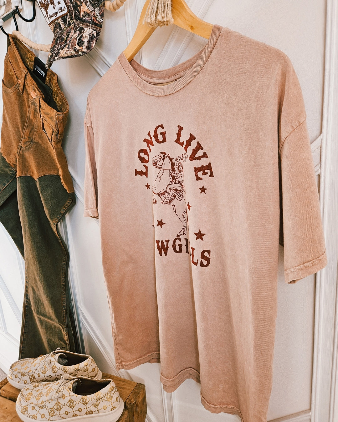 Close-up of the screen-printed cowgirl graphic on a pink vintage mineral wash t-shirt