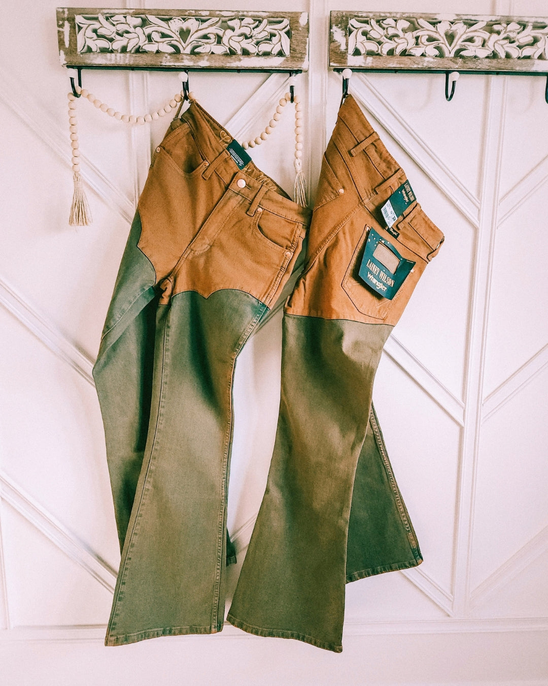 Wrangler x Lainey Wilson brown chap jeans hanging, showing the high-rise waist and flared legs