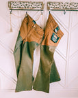 Wrangler x Lainey Wilson brown chap jeans hanging, showing the high-rise waist and flared legs