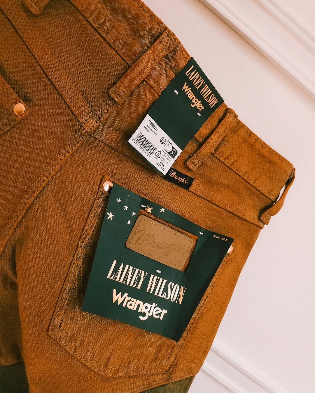 Close-up of the Wrangler x Lainey Wilson labels on the brown chap jeans