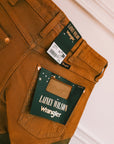 Close-up of the Wrangler x Lainey Wilson labels on the brown chap jeans