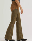 Side view of Wrangler x Lainey Wilson two-tone chap jeans with a high-rise tan top, olive-brown flared legs and black cowboy boots