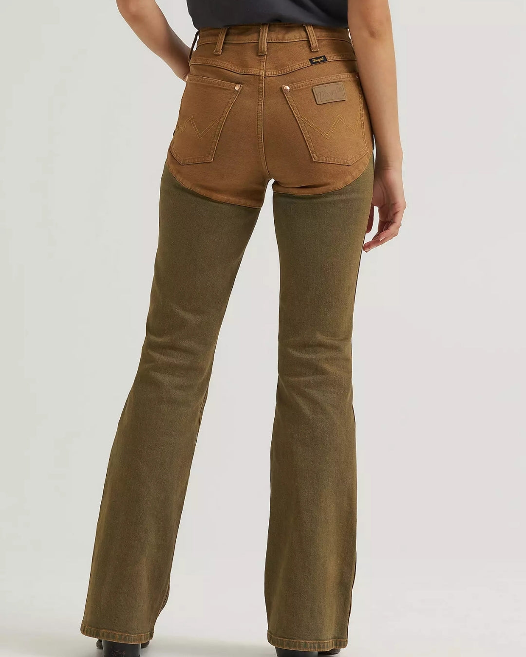 Rear view of Wrangler x Lainey Wilson brown chap jeans showing back pockets, Wrangler patch and curved chap-style panel seams