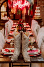 white wedding cowboy boots placed on a wedding table